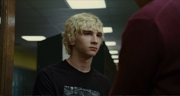 Movie still from “Win Win” (2011), directed by Tom McCarthy – A young man with blonde hair is looking at the camera; Close Up shot, Over the shoulder angle