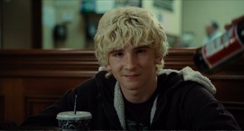 Movie still from “Win Win” (2011), directed by Tom McCarthy – A man with blonde hair sitting at a table with a drink; Close Up shot, Over the shoulder angle