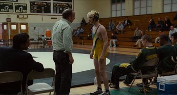 Movie still from “Win Win” (2011), directed by Tom McCarthy – A man and a woman are talking to each other in a wrestling ring; Medium shot, Over the shoulder angle