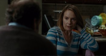 Movie still from “Win Win” (2011), directed by Tom McCarthy – A woman sitting in front of a man in front of a table; Medium shot, Over the shoulder angle