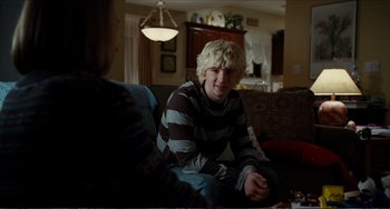 Movie still from “Win Win” (2011), directed by Tom McCarthy – A young man sitting on a couch in a living room; Medium shot, Over the shoulder angle