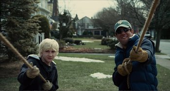Movie still from “Win Win” (2011), directed by Tom McCarthy – A man and a boy are standing in the grass; Medium shot, Over the shoulder angle