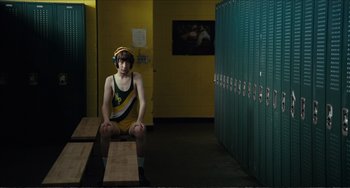 Movie still from “Win Win” (2011), directed by Tom McCarthy – A man sitting on a bench in front of some lockers; Wide shot, Over the shoulder angle