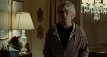 Movie still from “Win Win” (2011), directed by Tom McCarthy – A young man standing in a room with a lamp; Medium shot, Over the shoulder angle