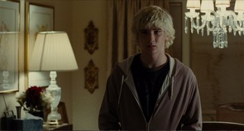 Movie still from “Win Win” (2011), directed by Tom McCarthy – A young man standing in a room with a lamp; Medium shot, Over the shoulder angle
