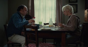 Movie still from “Win Win” (2011), directed by Tom McCarthy – Two people sitting at a dining room table eating food; Medium shot, High angle