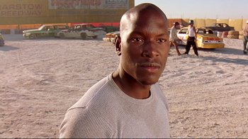 Movie still from “2 Fast 2 Furious” (2003), directed by John Singleton – A man in a white shirt is standing in the dirt; Close Up shot, Low angle