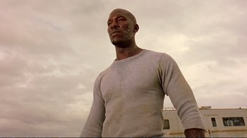 Movie still from “2 Fast 2 Furious” (2003), directed by John Singleton – A bald man in a white shirt is looking up; Close Up shot, Low angle