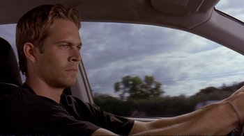 Movie still from “2 Fast 2 Furious” (2003), directed by John Singleton – A person in a car on the road; Close Up shot, Over the shoulder angle