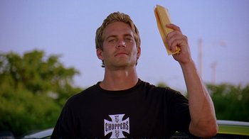 Movie still from “2 Fast 2 Furious” (2003), directed by John Singleton – A man holding a hot dog in one hand and a bun in the other; Close Up shot, Low angle
