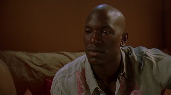 Movie still from “2 Fast 2 Furious” (2003), directed by John Singleton – A person sitting on a couch; Close Up shot, High angle