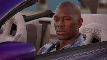 Movie still from “2 Fast 2 Furious” (2003), directed by John Singleton – A man sitting in the back seat of a car; Close Up shot, Low angle