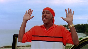 Movie still from “2 Fast 2 Furious” (2003), directed by John Singleton – A man in a red and white striped shirt with his hands up; Medium shot, Low angle