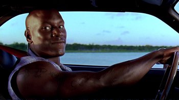 Movie still from “2 Fast 2 Furious” (2003), directed by John Singleton – A man sitting in the driver's seat of a car; Close Up shot, Over the shoulder angle