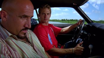 Movie still from “2 Fast 2 Furious” (2003), directed by John Singleton – Two men sitting in the drivers seat of a car; Close Up shot, Over the shoulder angle