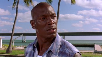 Movie still from “2 Fast 2 Furious” (2003), directed by John Singleton – A person wearing a plaid shirt near the ocean; Close Up shot, Low angle