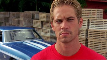 Movie still from “2 Fast 2 Furious” (2003), directed by John Singleton – A person wearing a red t - shirt; Close Up shot, Over the shoulder angle