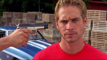 Movie still from “2 Fast 2 Furious” (2003), directed by John Singleton – A person holding a gun; Close Up shot, Over the shoulder angle