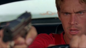 Movie still from “2 Fast 2 Furious” (2003), directed by John Singleton – A man holding a cell phone while sitting in a car; Close Up shot, Over the shoulder angle
