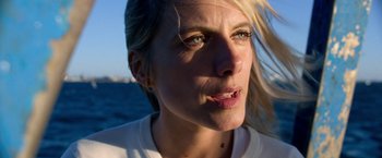 Movie still from “6 Underground” (2019), directed by Michael Bay – A woman's face in front of the ocean; Close Up shot, Low angle