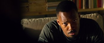 Movie still from “6 Underground” (2019), directed by Michael Bay – A person sitting on a couch; Close Up shot, Low angle