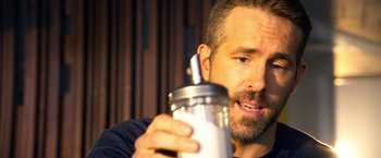 Movie still from “6 Underground” (2019), directed by Michael Bay – A person holding a drink in a cup; Close Up shot, Over the shoulder angle