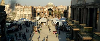 Movie still from “6 Underground” (2019), directed by Michael Bay – A group of people walking on a sidewalk near a building; Extreme Wide shot, High angle