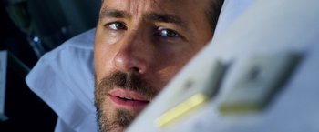 Movie still from “6 Underground” (2019), directed by Michael Bay – A man with a beard looking at the camera; Extreme Close Up shot, Low angle