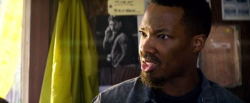 Movie still from “6 Underground” (2019), directed by Michael Bay – A person with a beard; Close Up shot, Over the shoulder angle