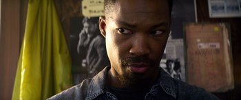 Movie still from “6 Underground” (2019), directed by Michael Bay – A person wearing a black shirt; Close Up shot, Over the shoulder angle