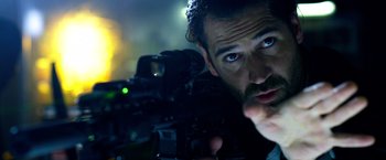Movie still from “6 Underground” (2019), directed by Michael Bay – A person holding a camera; Close Up shot, Over the shoulder angle