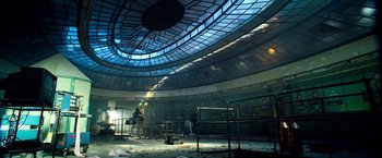 Movie still from “6 Underground” (2019), directed by Michael Bay – Two men working in a large room with a large ceiling; Extreme Wide shot, Low angle