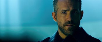 Movie still from “6 Underground” (2019), directed by Michael Bay – A man's face in front of a blue background; Close Up shot, Over the shoulder angle