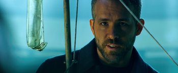 Movie still from “6 Underground” (2019), directed by Michael Bay – A person with a beard; Close Up shot, Over the shoulder angle