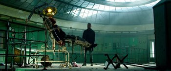 Movie still from “6 Underground” (2019), directed by Michael Bay – A man standing next to an empty hospital bed; Wide shot, Low angle