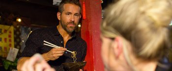 Movie still from “6 Underground” (2019), directed by Michael Bay – A man holding chopsticks while eating noodles; Close Up shot, Over the shoulder angle