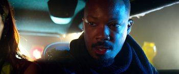 Movie still from “6 Underground” (2019), directed by Michael Bay – A person in a car looking at the camera; Close Up shot, Low angle