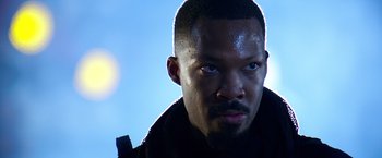 Movie still from “6 Underground” (2019), directed by Michael Bay – A person wearing a black jacket; Close Up shot, Low angle