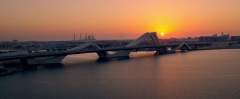 Movie still from “6 Underground” (2019), directed by Michael Bay – The sun is setting over a large body of water; Extreme Wide shot, High angle