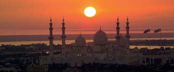 Movie still from “6 Underground” (2019), directed by Michael Bay – The sun is setting over a large city with domes; Extreme Wide shot, Low angle