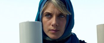 Movie still from “6 Underground” (2019), directed by Michael Bay – A person wearing a headscarf; Close Up shot, Low angle