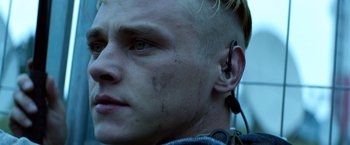 Movie still from “6 Underground” (2019), directed by Michael Bay – A person wearing a ear piece; Close Up shot, Low angle