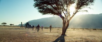 Movie still from “6 Underground” (2019), directed by Michael Bay – A group of people walking on a dirt field; Extreme Wide shot, Low angle