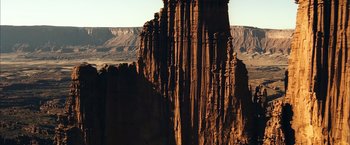 Movie still from “6 Underground” (2019), directed by Michael Bay – A tall rock formation in the middle of the desert; Extreme Wide shot, Low angle