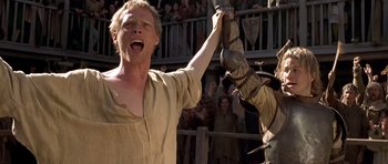 Movie still from “A Knight's Tale” (2001), directed by Brian Helgeland – A man holding onto a horse in front of a crowd of onlookers; Medium shot, Low angle