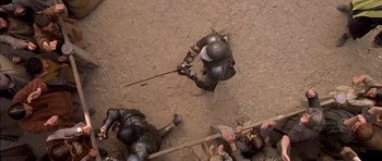 Movie still from “A Knight's Tale” (2001), directed by Brian Helgeland – A group of people in medieval armor on a dirt ground; Wide shot, Overhead angle