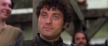 Movie still from “A Knight's Tale” (2001), directed by Brian Helgeland – A person wearing a black jacket; Close Up shot, Low angle