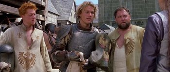 Movie still from “A Knight's Tale” (2001), directed by Brian Helgeland – Two men in medieval garb standing next to each other; Medium shot, Over the shoulder angle