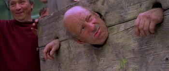 Movie still from “A Knight's Tale” (2001), directed by Brian Helgeland – An older man is poking his head through a fence; Close Up shot, Low angle