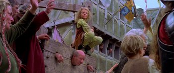 Movie still from “A Knight's Tale” (2001), directed by Brian Helgeland – A young girl hanging from a wooden beam; Medium shot, Over the shoulder angle